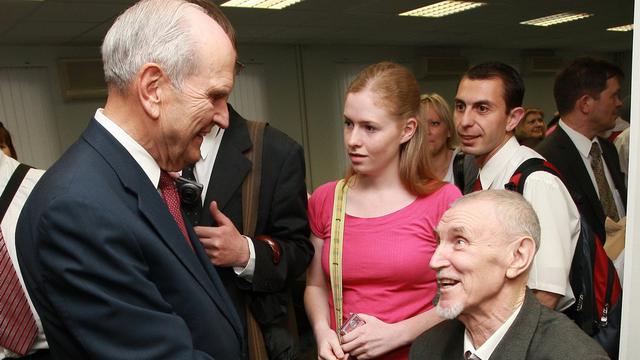 Elder Russell M. Nelson accueille un membre de l'Église à Moscou, en Russie.